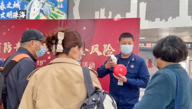 消防指战员向旅客介绍消防设施的使用方法.jpg